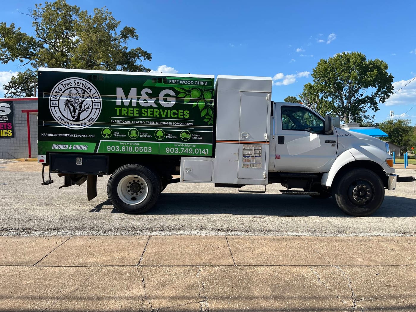 Side view of the M&G Tree Services truck, green and white